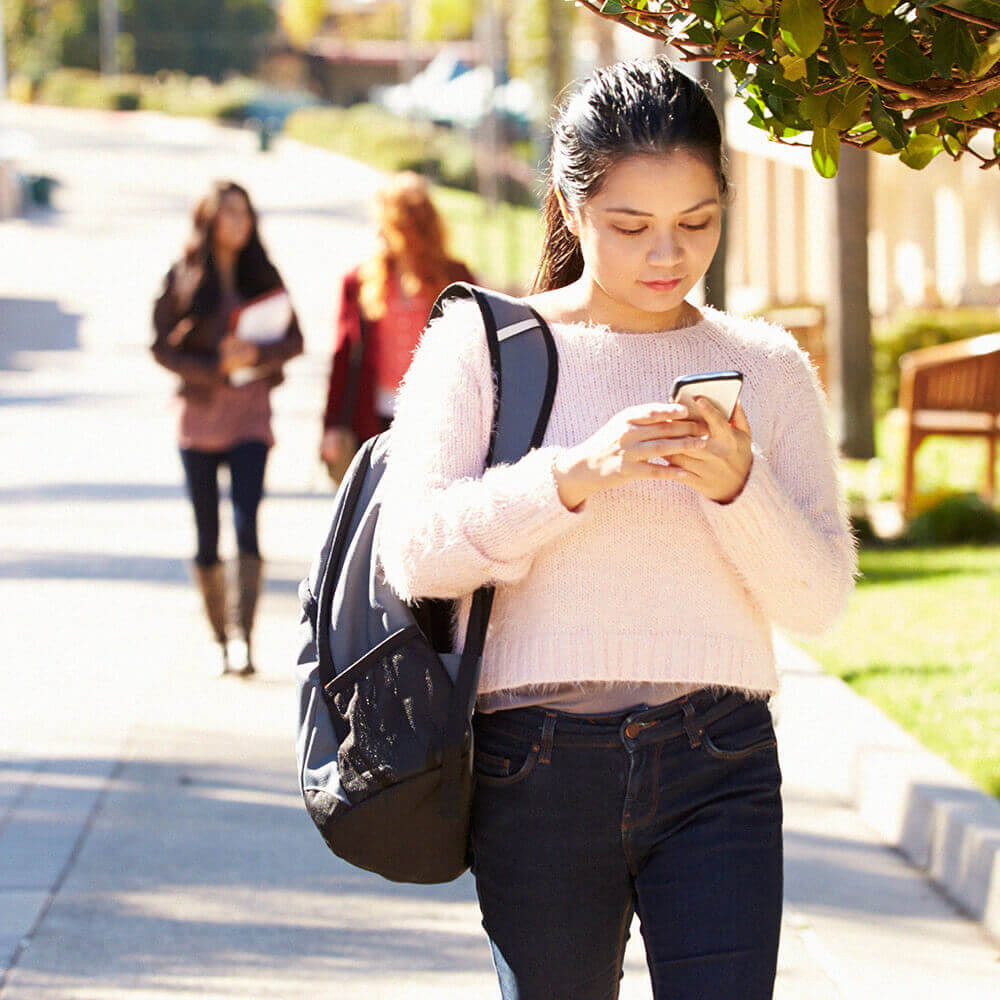 student walking and texting on phone