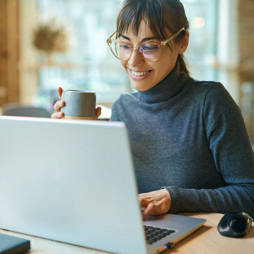 smiling woman watching webinar on laptop