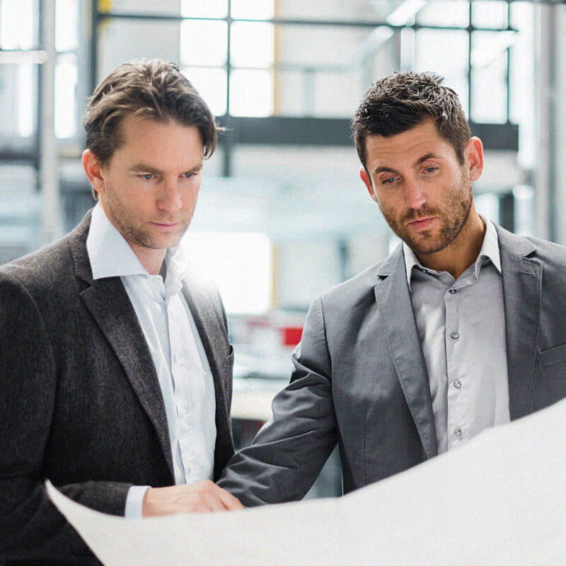 two businessmen looking at building plans