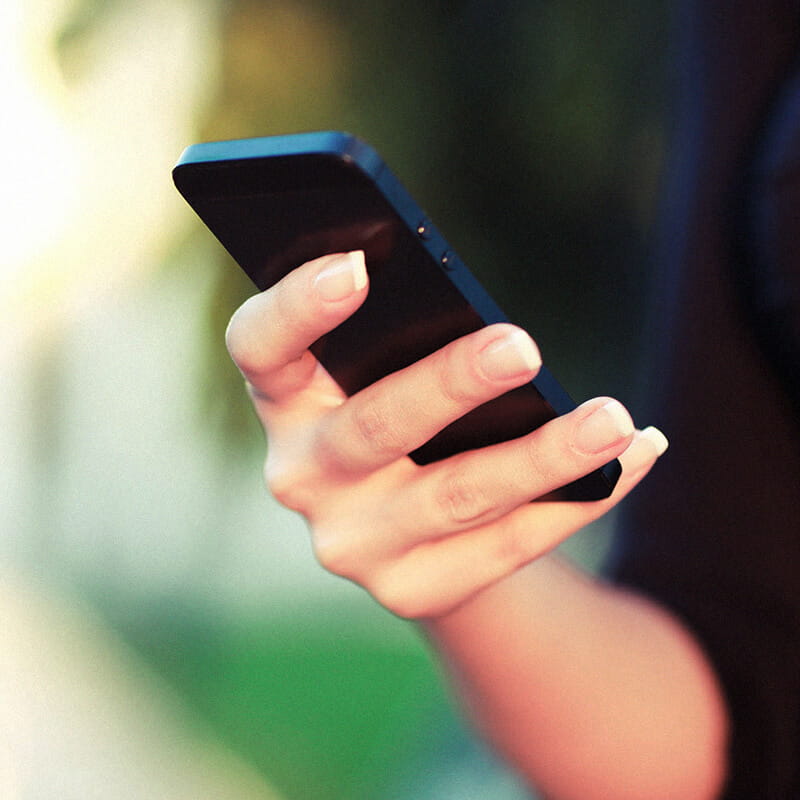 close up of woman's hand using mobile phone