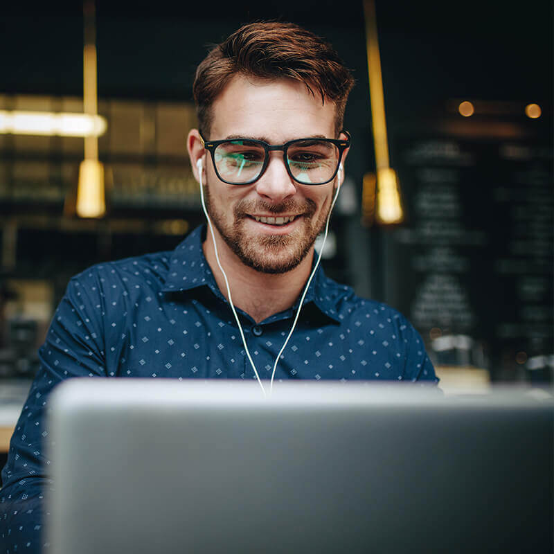 Man with glasses looking at computer screen