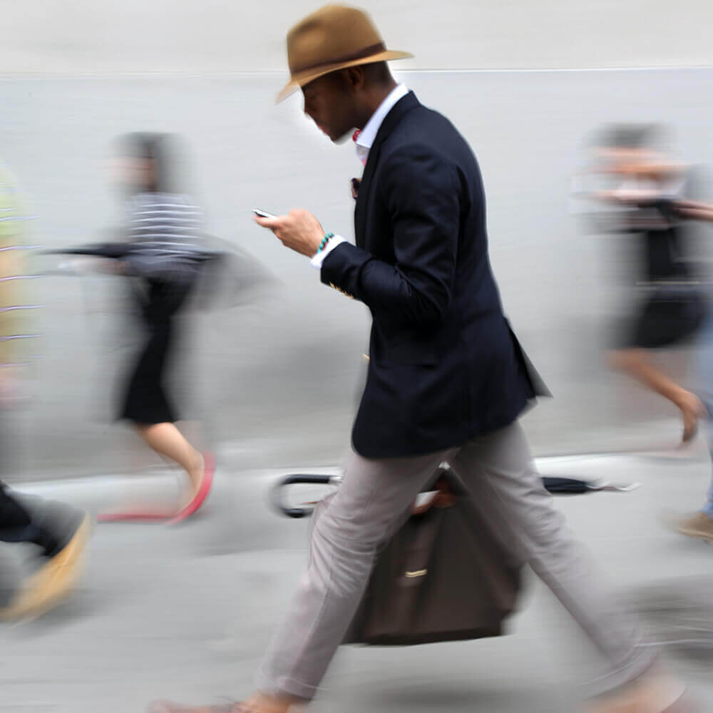 man walking and looking at a mobile phone