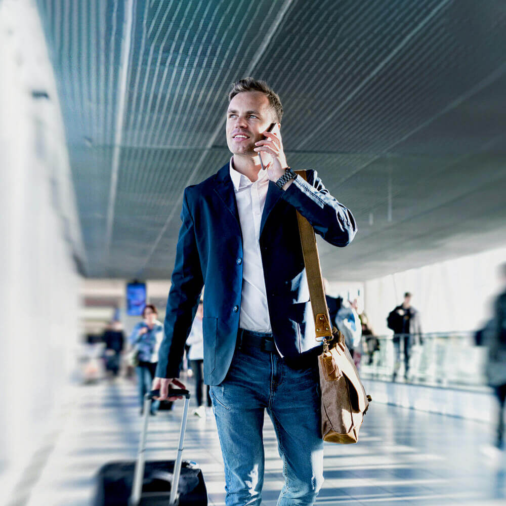 Man walking with luggage and talking on the phone