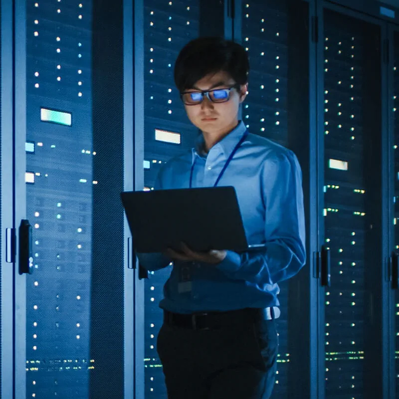 man using a laptop in server room